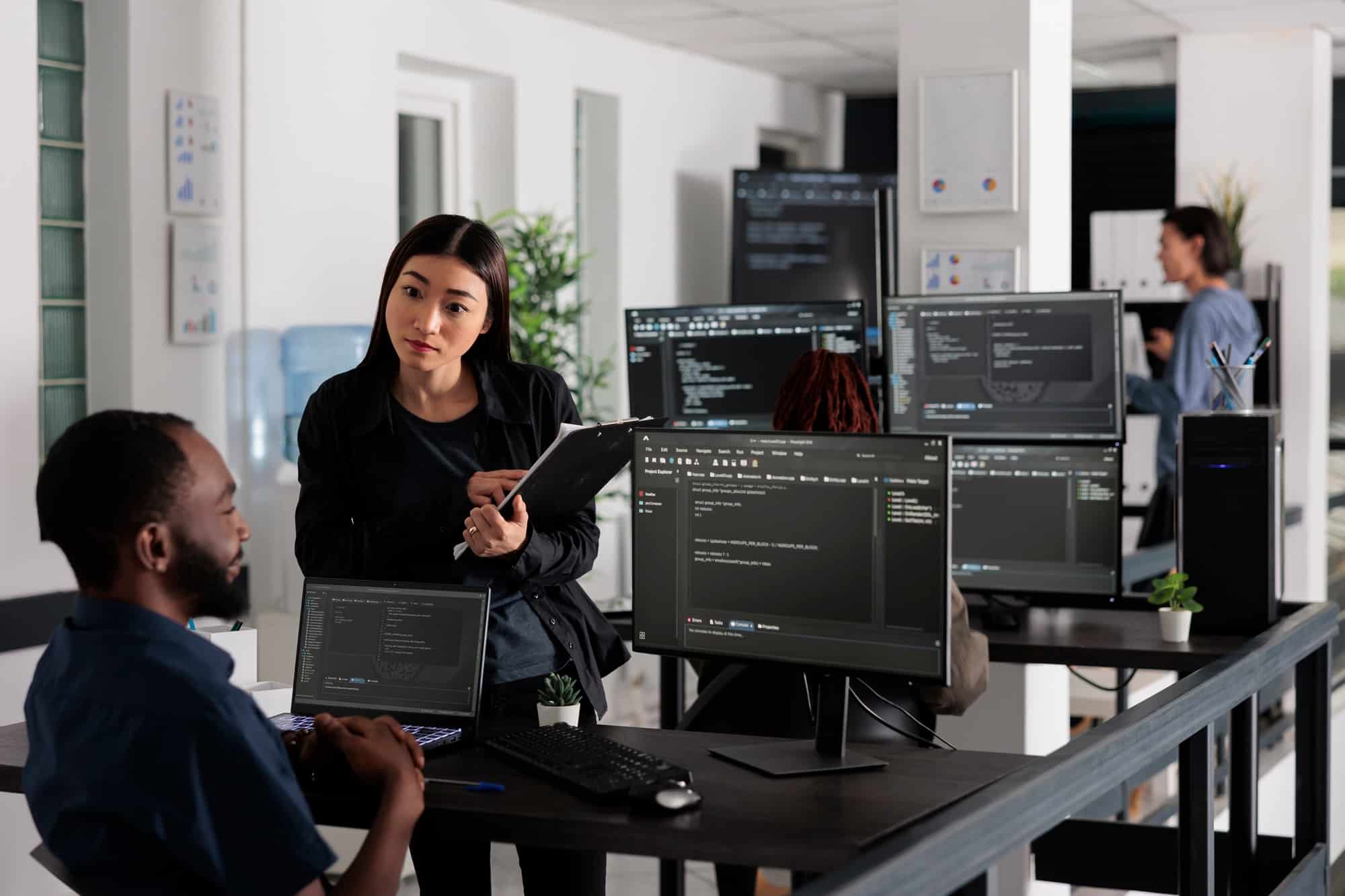 Team of system engineers working on software development with source code